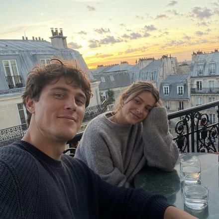 Couple sur un balcon parisien au coucher du soleil